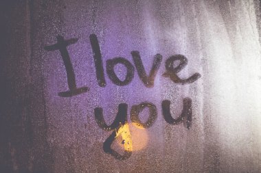 Doku su damlaları vardır bir parıltı ve buğulu aracılığıyla ışık penceresi üzerinde. Seni parmağında buğulu cam pencere tarafından yazıldı seviyorum metin.