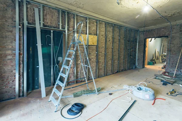 在公寓内建造梯子和工具的石膏墙用石膏板 石膏板 安装金属框架的工作过程正在建设中 恢复和重建 — 图库照片