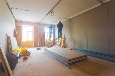 Alçıpan (Pano) için yükleme metal çerçeve sürecinin dairede alçı duvarlar merdiven ve araçları ile yapmak için yapım aşamasında, tadilat, yenileme, uzantısı, restorasyon ve rekonstrüksiyon çalışıyor