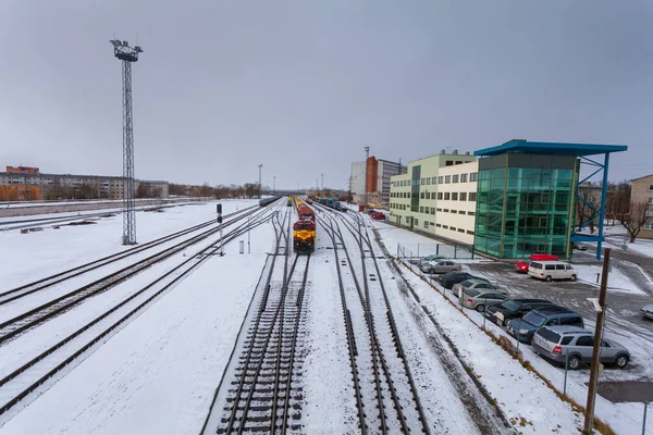 Narva, Estland - 23. Februar 2017: Der Güterzug, der aus Diesellokomotive und vielen Waggons besteht, wartet auf das erlaubte grüne Signal der Semaphore auf der Winterbahn in Narva. — Stockfoto