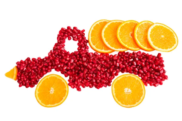 Concept d'alimentation saine avec des fruits. Les graines de grenade et les tranches d'orange ont la forme d'un camion avec une cargaison d'orange — Photo