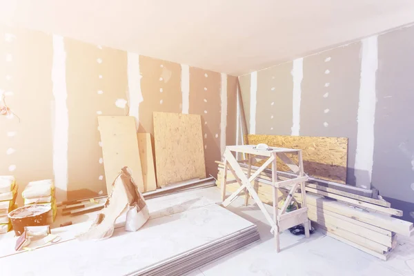 Materials for construction - putty packs, sheets of plasterboard or drywall- in apartment is under construction, remodeling, renovation, extension, restoration and reconstruction. — Stock Photo, Image