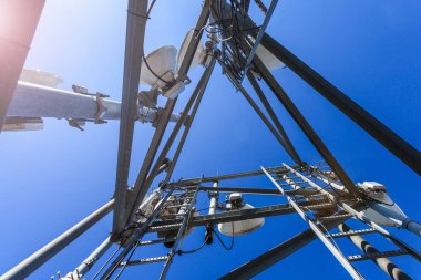 İç görünüm telekomünikasyon kule mikrodalga, radyo antenleri ve kabloları mavi gökyüzü ve güneş karşı. İç görünüm.