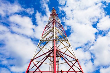 Telekomünikasyon kule ile paneli antenler ve radyo antenleri ve çanak antenler mobil iletişim 2g, 3g, 4g, 5g kule mavi gökyüzü bulutlar ile etrafında kırmızı çit ile için