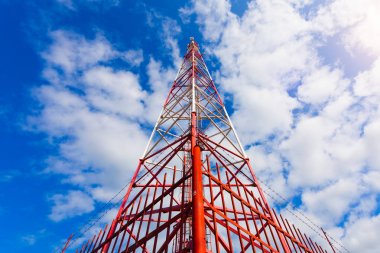 Telekomünikasyon kule ile paneli antenler ve radyo antenleri ve çanak antenler mobil iletişim 2g, 3g, 4g, 5g kule mavi gökyüzü bulutlar ile etrafında kırmızı çit ile için