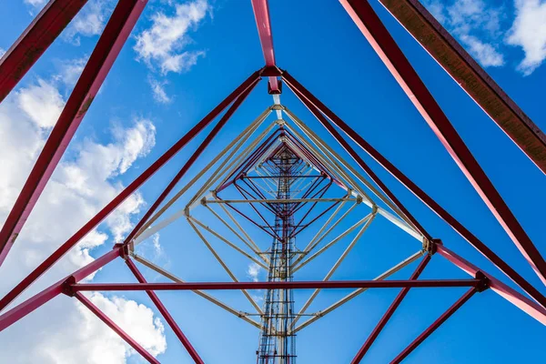 Tour de télécommunication avec antennes de panneaux et antennes radio et antennes paraboliques pour communications mobiles 2G, 3G, 4G, 5G avec clôture rouge autour de la tour contre le ciel bleu avec nuages — Photo
