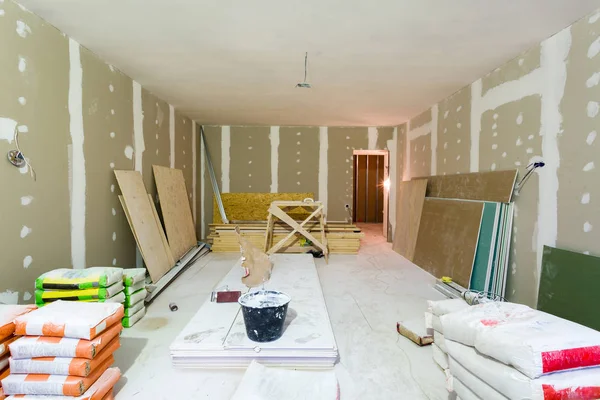 Materialen voor bouw stopverf packs, vellen gipskarton of gipsplaten in appartement is onder constructie, verbouwing, renovatie, uitbreiding, herstel en wederopbouw — Stockfoto