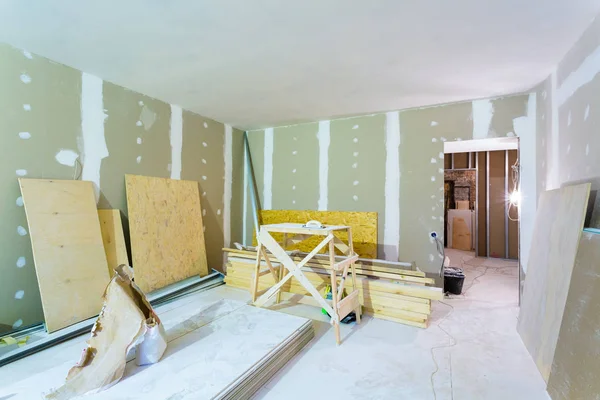 Materials for construction - putty packs, sheets of plasterboard or drywall- in apartment is under construction, remodeling, renovation, extension, restoration and reconstruction. — Stock Photo, Image