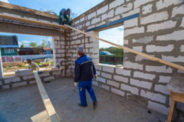 Bulanık binanın çatı ve malzemelerle inşaat ve işçiler için yapım aşamasındadır. Bokeh etkisi ile inşaat kavramının arka plan bulanık.