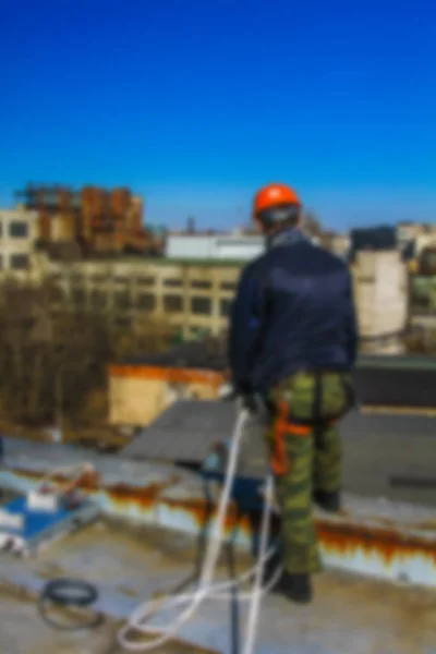 Blurred professional industrial climbers in helmet and uniform works at height for instaling communication equipment and antenna.