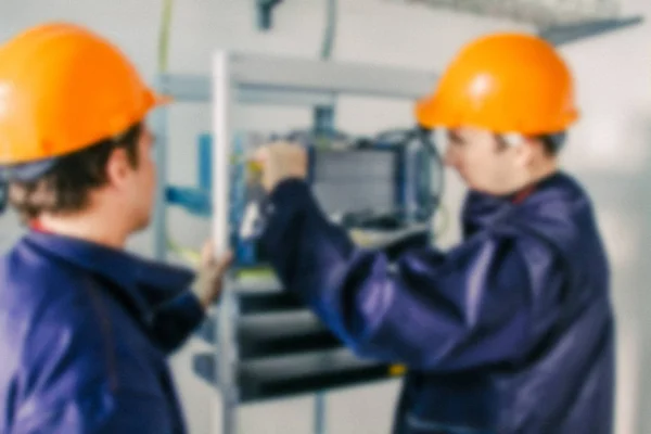 Des ingénieurs professionnels flous installent des équipements de communication à l'intérieur de la station de communication de base . — Photo