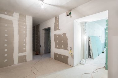 Metal frames and plasterboard -drywall- for gypsum walls   and electric wires  in apartment is under construction, remodeling, renovation, extension, restoration and reconstruction clipart