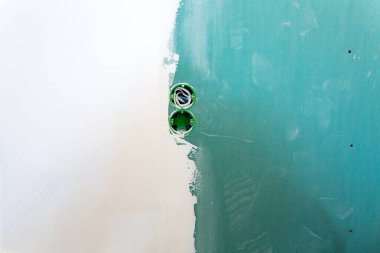 Tamamlanmamış çift elektrik prizi prizi prizinde mavi yapışkan bantlı elektrik prizi veya alçı taşı duvarları için alçıpan döşenmiş apartman ve tadilat ve tadilat aşamasında.