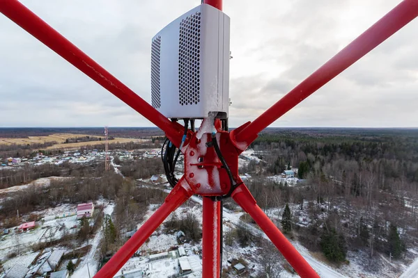 冬季有电力和光缆的红色电信塔或桅杆及远程电力倾斜和远程无线电装置 — 图库照片