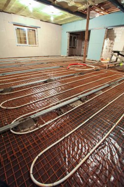 Boru tesisatçısı ısıtma ya da zemin altı ısıtma sistemi kuruyor. Su tabanındaki ısıtma sistemi. İnşaat, tadilat, tadilat, tadilat süresince apartmandaki tesisat boruları.