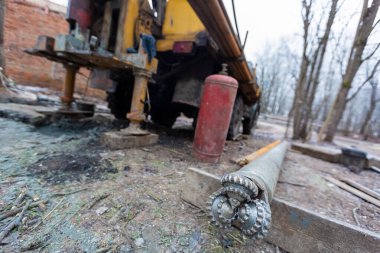 İnşaat alanında büyük tekerlekleri olan eski kamyona hidrolik yeraltı su kuyusu sondaj makinesi monte edildi. Yeraltı kuyusu sondajı..