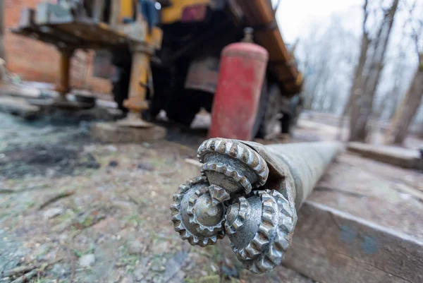 İnşaat alanında büyük tekerlekleri olan eski kamyona hidrolik yeraltı su kuyusu sondaj makinesi monte edildi. Yeraltı kuyusu sondajı..