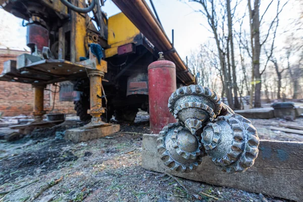 İnşaat alanında büyük tekerlekleri olan eski kamyona hidrolik yeraltı su kuyusu sondaj makinesi monte edildi. Yeraltı kuyusu sondajı..