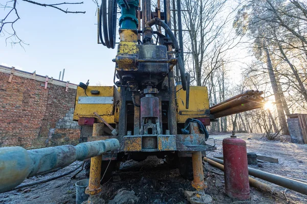 Hydraulic ground water hole drilling machine installed on the old truck with big wheels on the construction site. Groundwater well drilling.