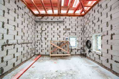 İçinde köpüklü beton bloktan, ahşap platformdan, elektrik kablolarından ve inşaat malzemelerinden yapılmış duvarlı bir binanın çalışma süreci. İnşaat kavramı, tadilat, renov