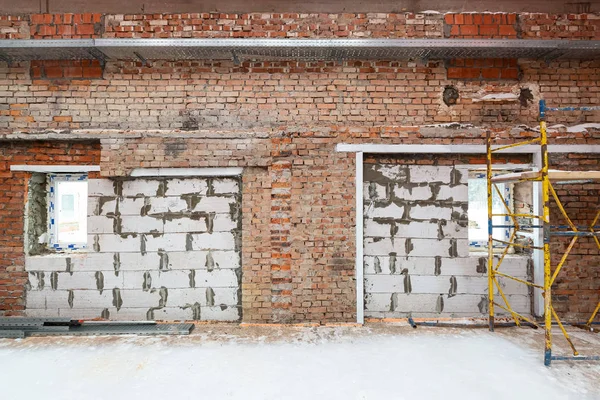 Inside view of working process of building house with wall made from foamed concrete block and metal platform. Concept of construction, remodeling, renovation, extension, restoration and — Stock Photo, Image