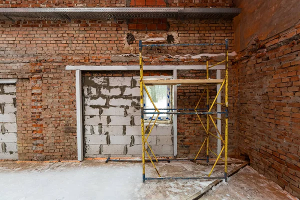 Inside view of working process of building house with wall made from foamed concrete block and metal platform. Concept of construction, remodeling, renovation, extension, restoration and — Stock Photo, Image