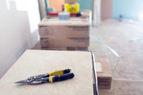 Bouwmes is op de tegel in de kamer van het appartement met bouwmaterialen die in aanbouw zijn, verbouwing, renovatie, revisie, uitbreiding, restauratie en wederopbouw. Concept — Stockfoto