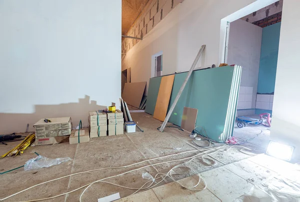 Werkproces van het installeren van gipsplaten of gipsplaten voor het maken van gipsplaten muren in appartement is in aanbouw, verbouwing, renovatie, uitbreiding, restauratie en wederopbouw. Begrip "thuis" — Stockfoto
