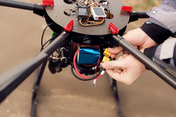 Mãos masculinas conectando uma bateria em um drone . — Fotografia de Stock