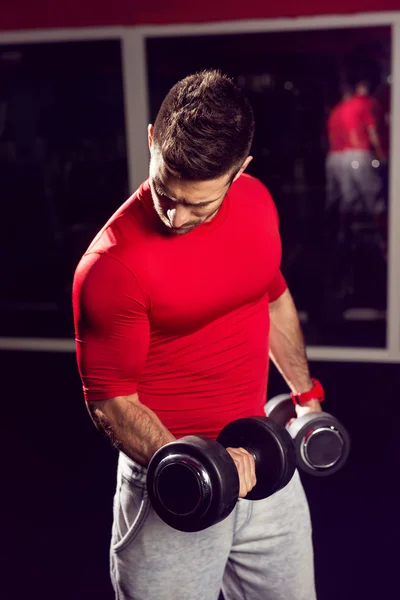 Homem muscular trabalhando com halteres — Fotografia de Stock