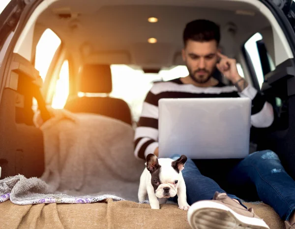 Premium Photo  Friends and a small puppy watching movie on their lap top.  having fun during a car trip.