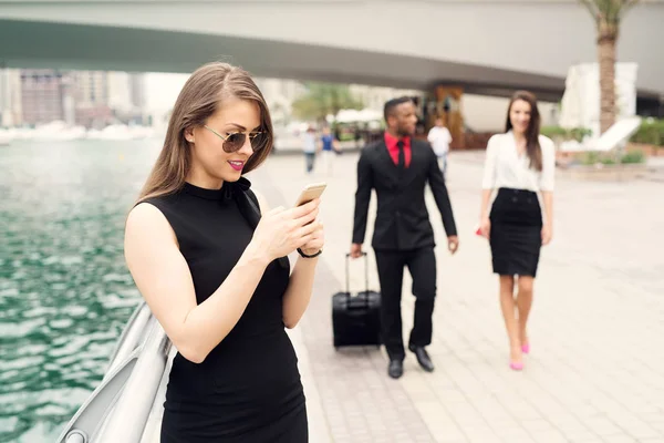 Business people walking on river sidewalk — Stock Photo, Image