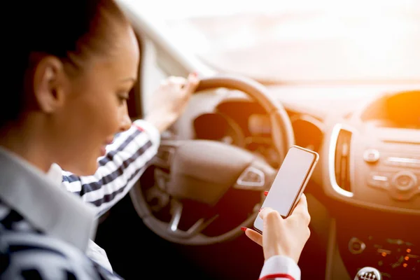 Mulher dirigindo carro e usando smartphone — Fotografia de Stock