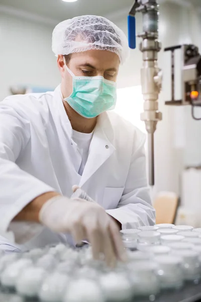 Man in gloves preparing cream — Stock Photo, Image