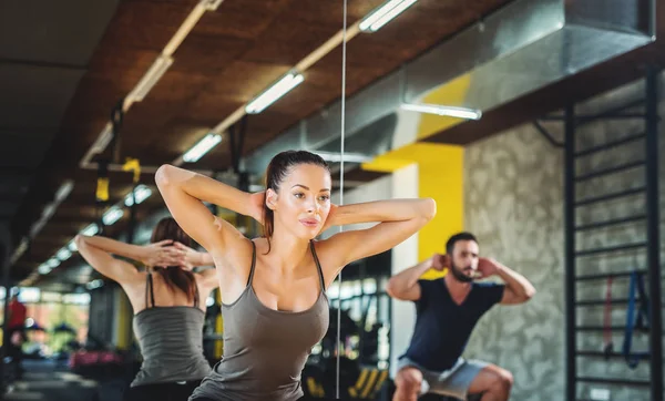 Pareja joven haciendo ejercicio en el gimnasio — Foto de Stock