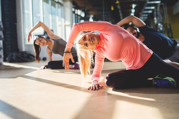 Pareja haciendo ejercicio con entrenador de fitness — Foto de Stock