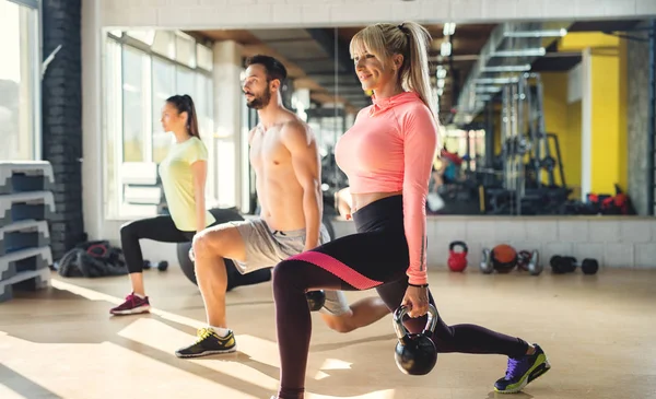 Pareja haciendo ejercicio con entrenador de fitness — Foto de Stock