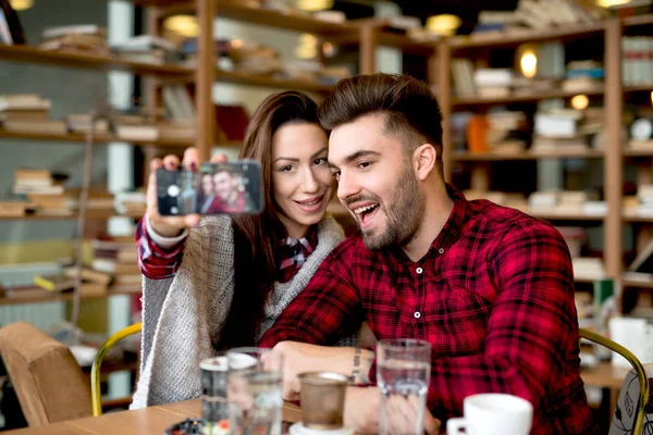 Met de smartphone bij restaurant (echt) paar — Stockfoto