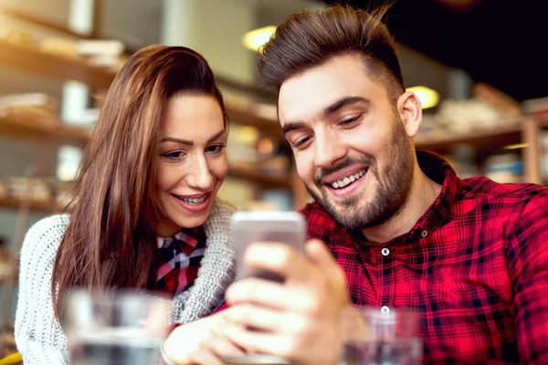 Et par med smarttelefon på restaurant – stockfoto