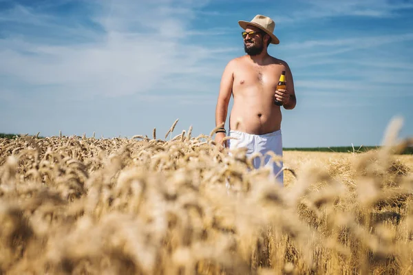 Agricultor com garrafa de urso no campo — Fotografia de Stock