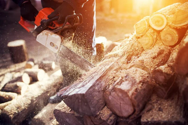 Mann schneidet Holz mit Kettensäge — Stockfoto