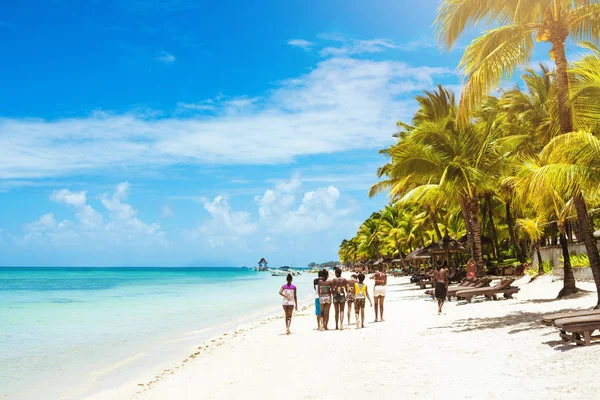 Groep mensen wandelen door strand — Stockfoto