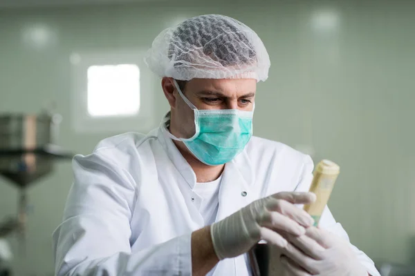 Фармацевтичний працівник перевіряє приклад крему — стокове фото