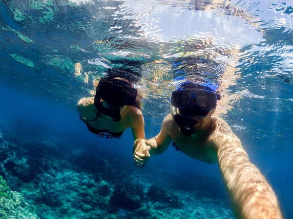 Mladý pár, potápění v křišťálově čistou vodou oceánu. Líbánky plné dobr — Stock fotografie