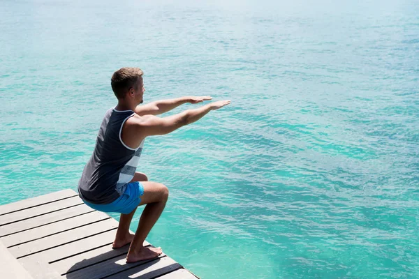 Спортсмен виконує вправи на морському причалі — стокове фото