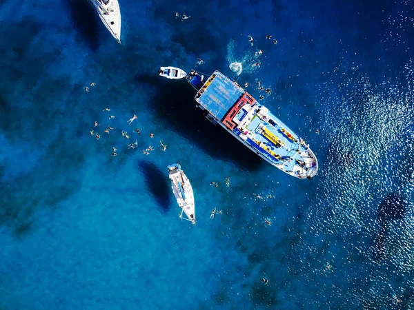Laguna con barca a vela e gente che nuota — Foto Stock