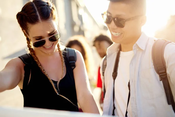 Couple of tourists looking at a map — Stock Photo, Image