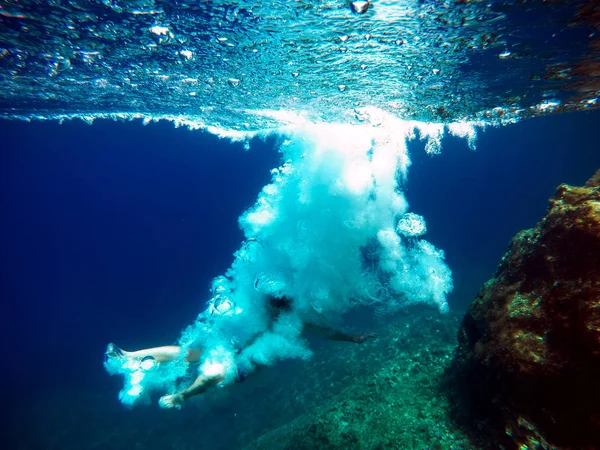 Homem pulando na água fazendo bolhas de ar . — Fotografia de Stock