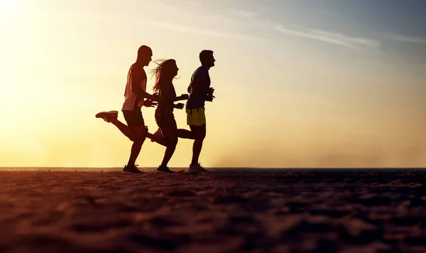 Junge Freunde rennen am Strand — Stockfoto