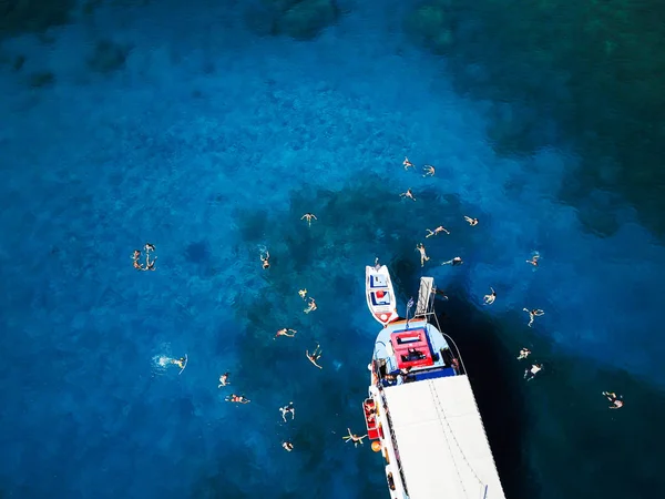 Laguna con barca a vela e gente che nuota — Foto Stock